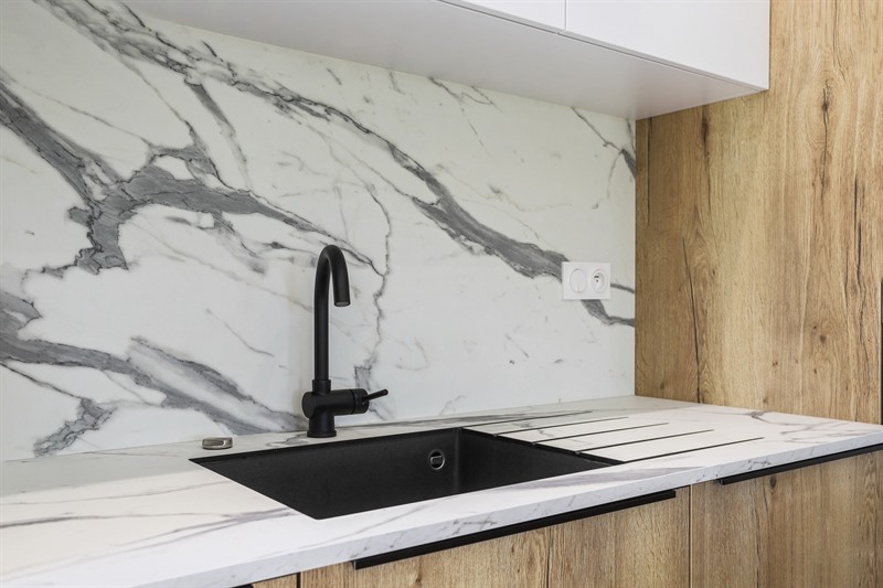 Cuisine ouverte de style industriel bois et noir à Cornille | Raison Home